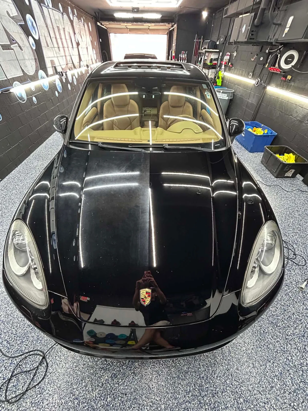 Black Porsche under the hexagonal lights in the studio, seen from above the hood